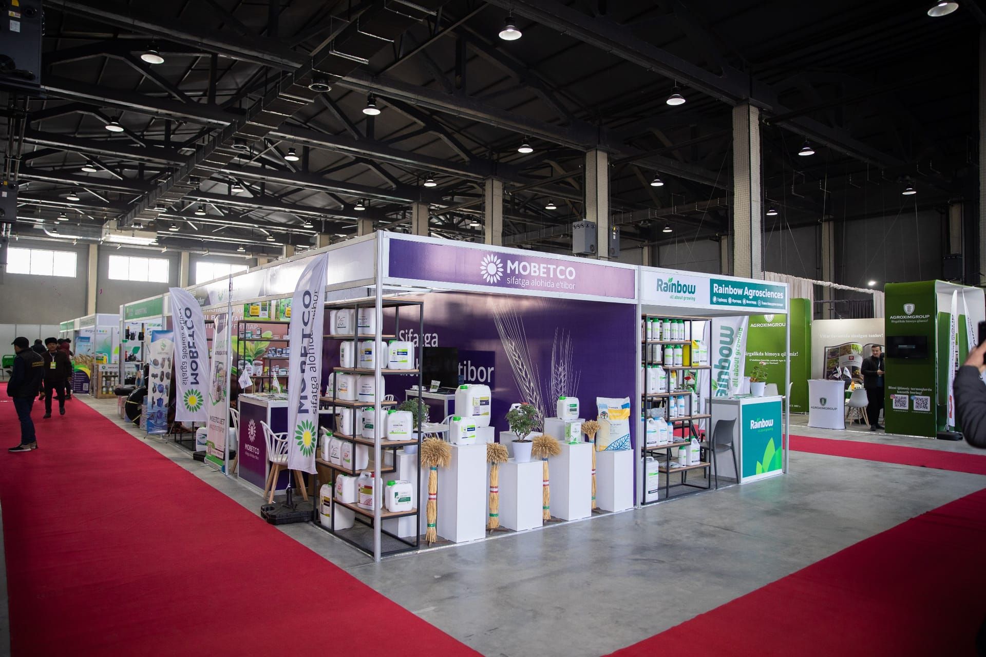 Koʻrgazma paytida SOF Expo yopiq pavilioni: stendlar va qizil gilamli yoʻlaklar