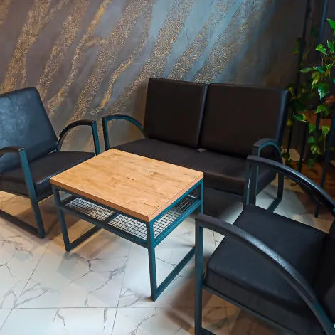 Loft uslubidagi qora charm divan, kreslolar va jurnal stoli